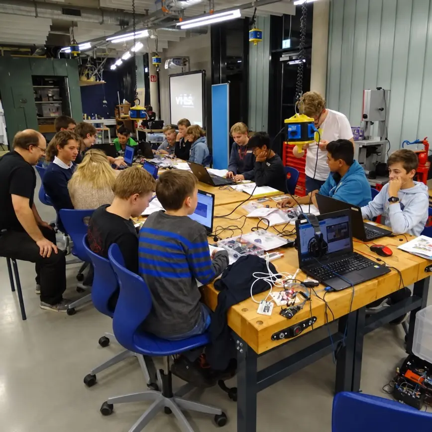 Zwei Kinder löten und bauen elektronische Schaltungen an einem Werktisch